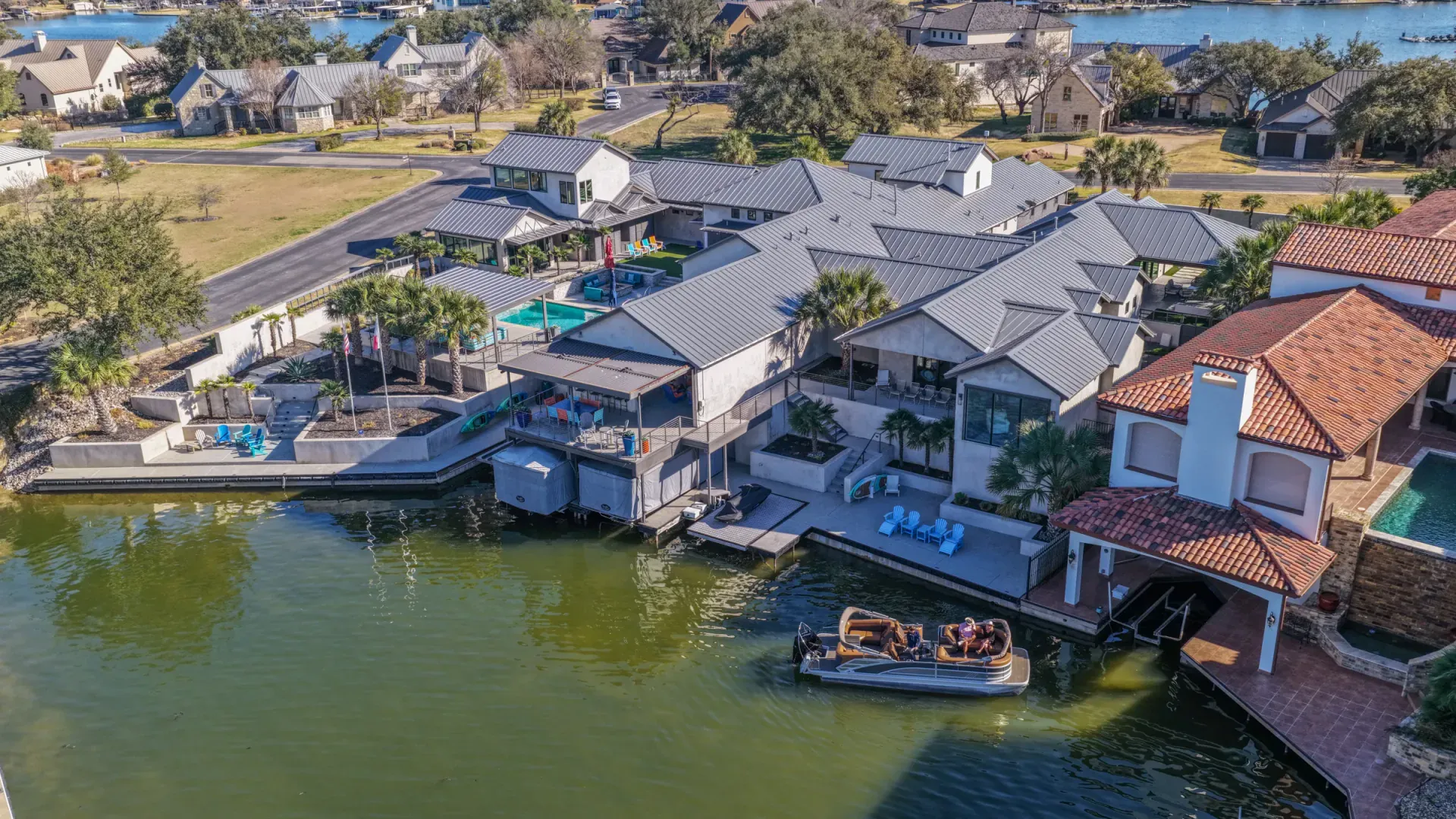 Aerial from waterside showing pool, dock, and boat